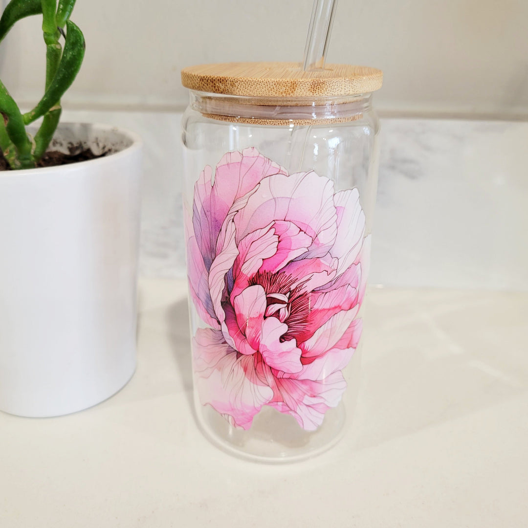 a 16 oz glass cup with a very large pink peony flower on the front of the cup