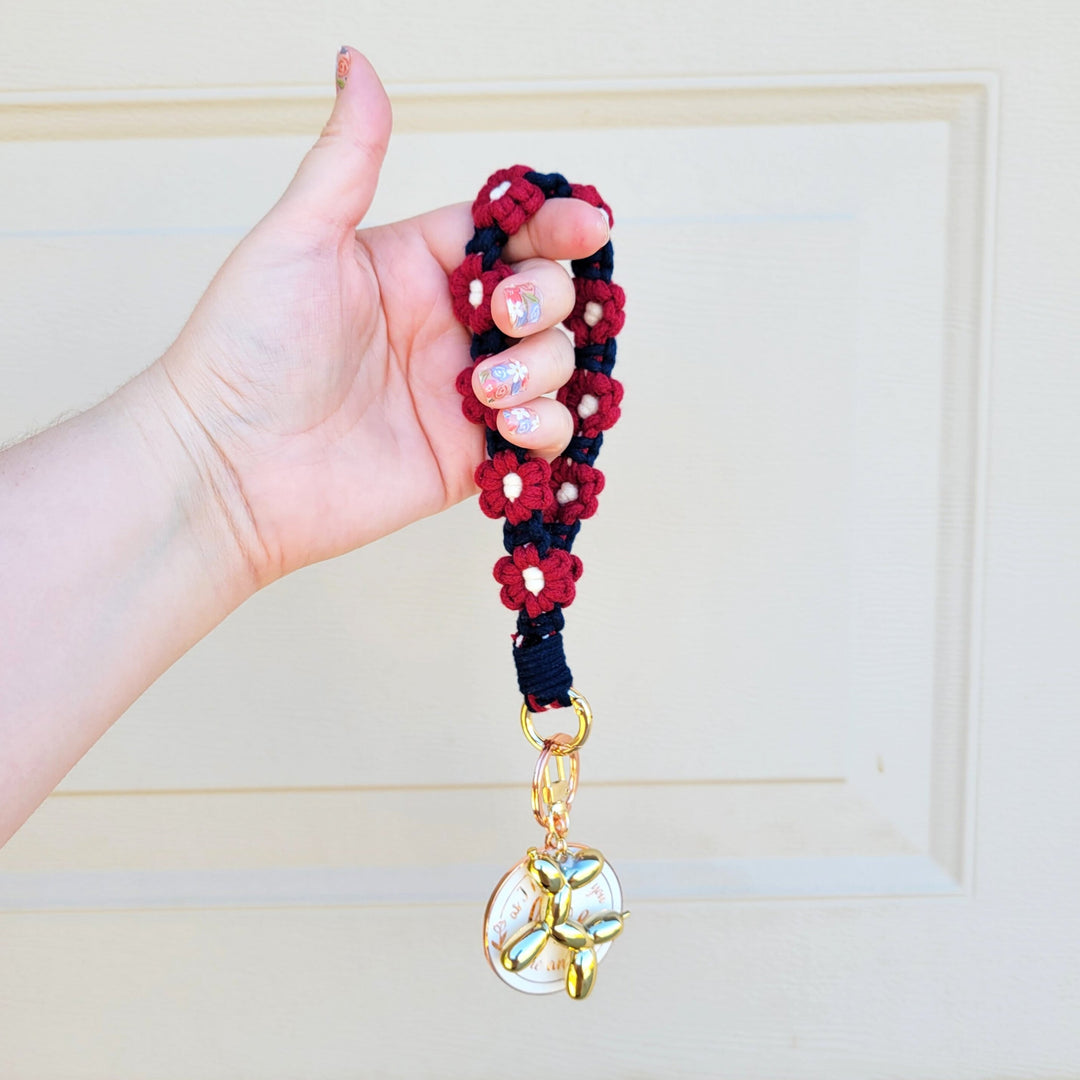 Blue and Maroon Flower Macrame Wristlet Keychain with gold clip hanging on hand