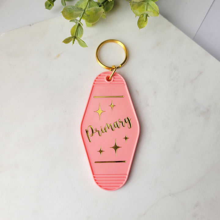retro shape salmon pink keychain, with 'Primary' in gold foil