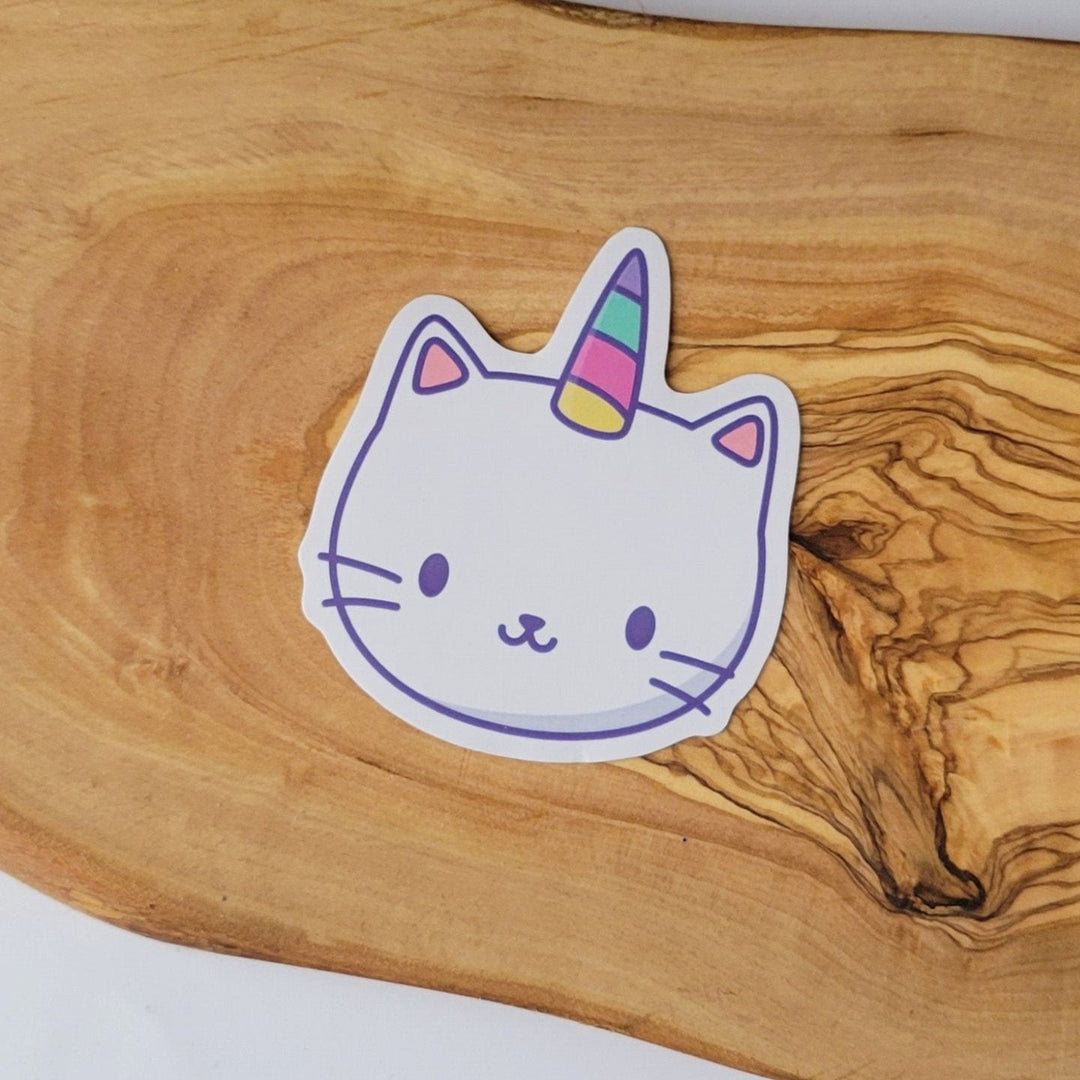 A white cat face with a colorful horn