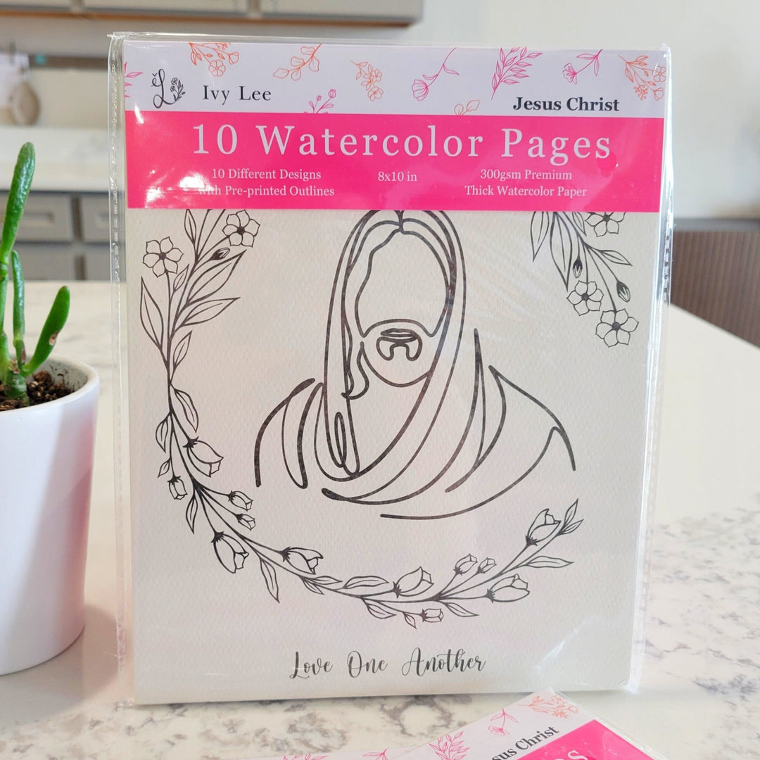 A watercolor pages packet with 10  pre printed pages of Jesus Christ. The package has bright pink and flowers, and shows the first picture of Jesus Christ, with a wreath of flowers lining his head.