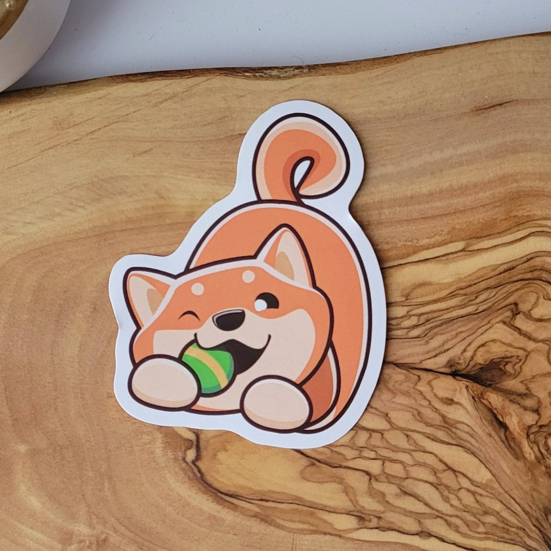 a tan and orange dog, chewing on a green ball