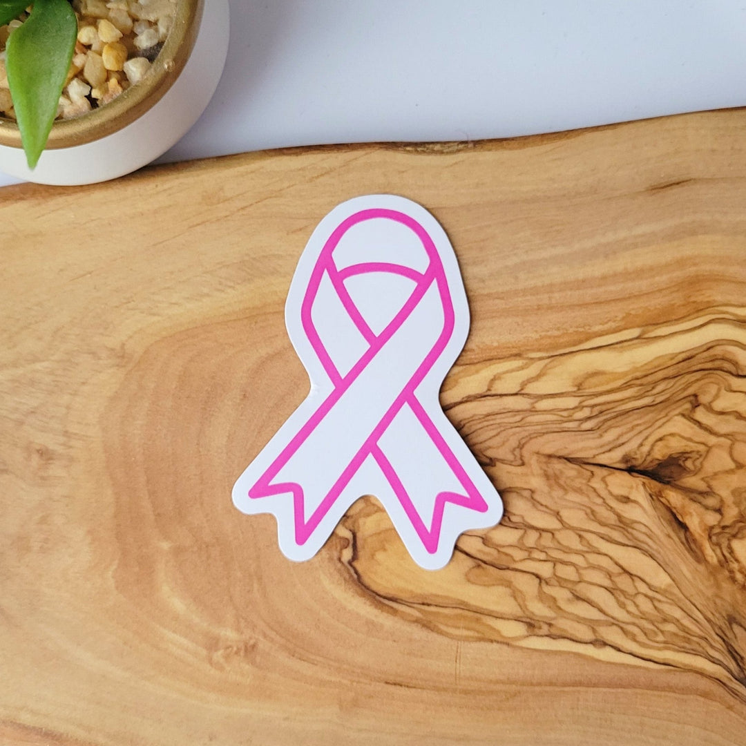 A white sticker of a pink outlined breast cancer ribbon