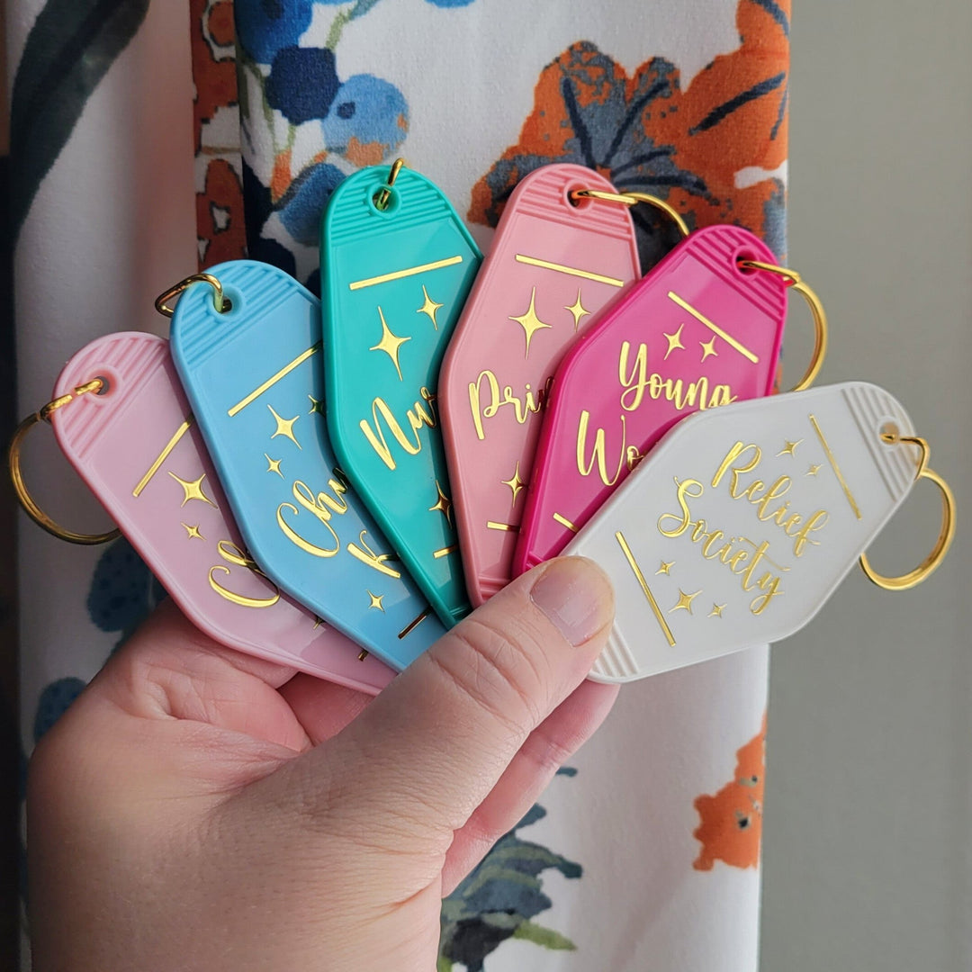 a group of retro style motel keychains, with gold rings, with several says on the front. "Church keys, Nursery, Primary, Young Woman, and Relief Society."