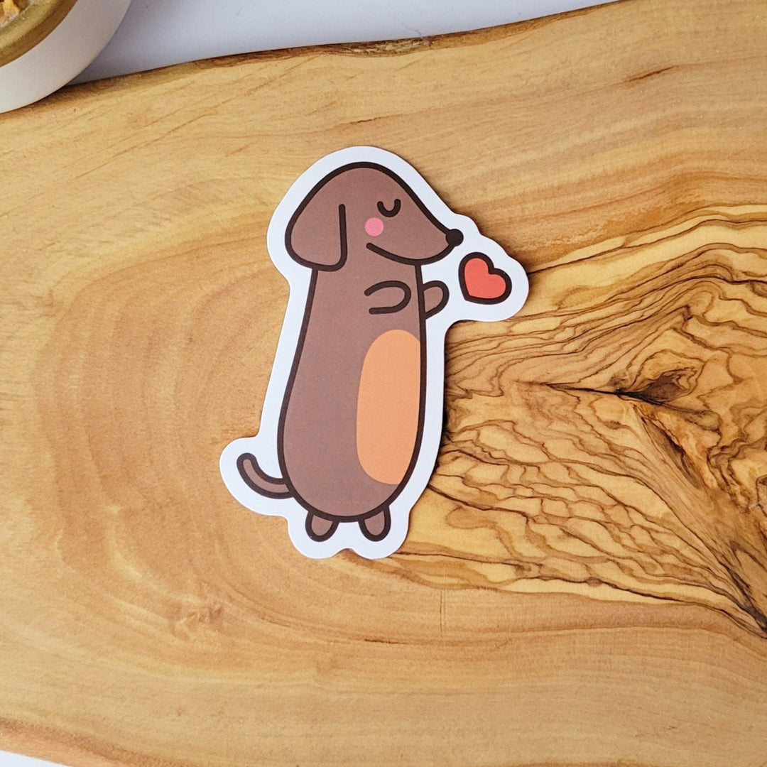 a brown dog with a red heart next to it