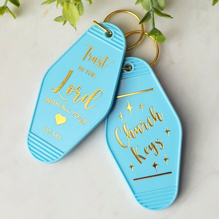 "Blue retro motel-style keychain with gold foil on both sides, featuring 'Church Keys' on the front and 'Trust In the Lord With All Your Heart' on the back, with a gold ring