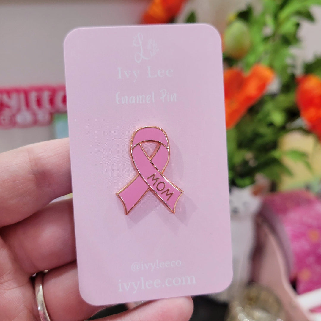pink cancer ribbon shaped pin on a pink backing card