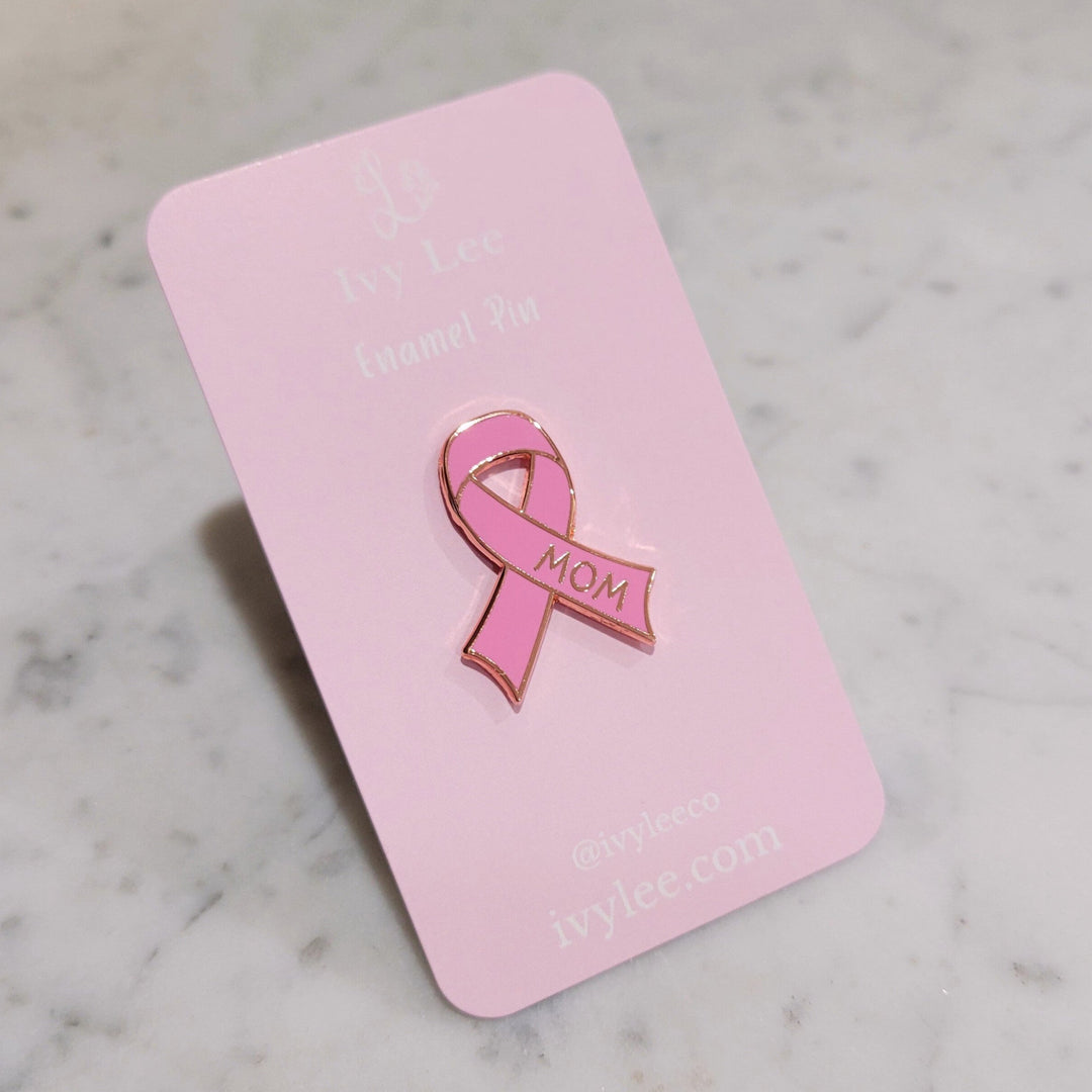 pink cancer ribbon shaped pin on a pink card