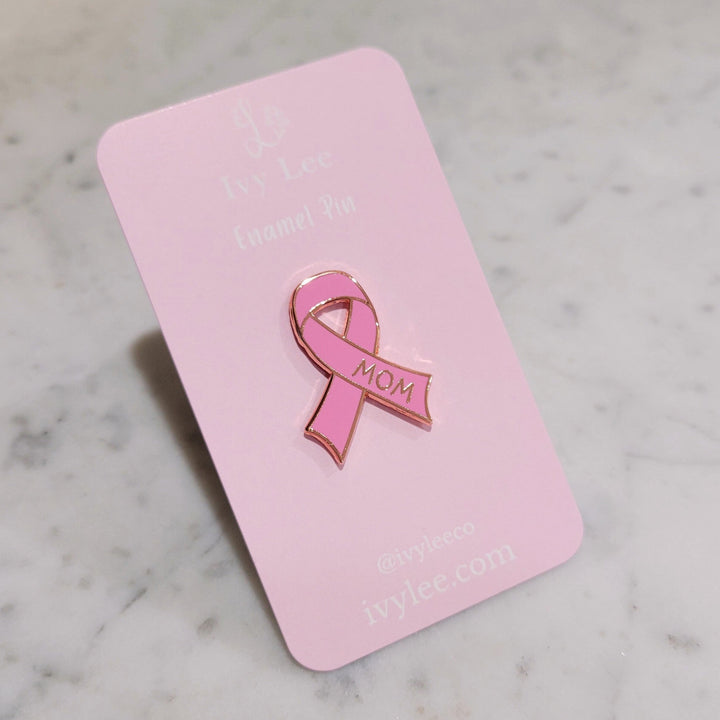 pink cancer ribbon shaped pin on a pink card
